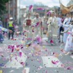 Procesión de Corpus Christi con niños lanzando pétalos de flores en la calle. Corpus Christi en RD: feriado legal,