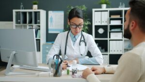 Doctora completando expediente clínico durante consulta médica con paciente